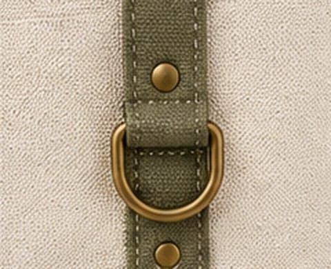 Close-up of the antique brass D-ring and rivets on the contrast strap