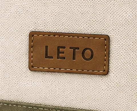 Close-up of the leather-look brand patch stitched to the canvas body